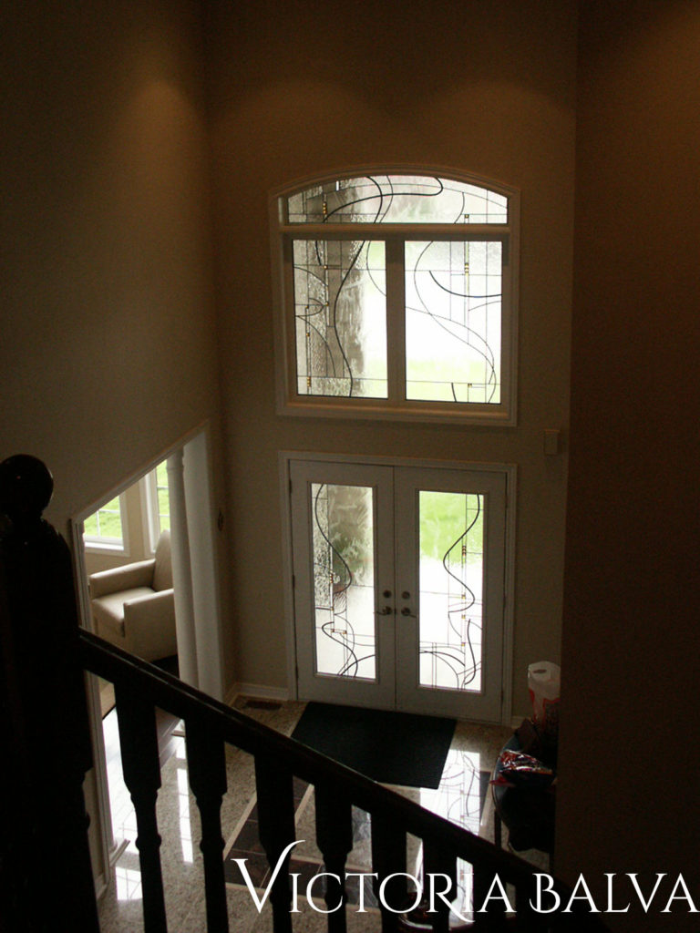 Double-height entrance foyer with comtemporary simple stained and leaded glass