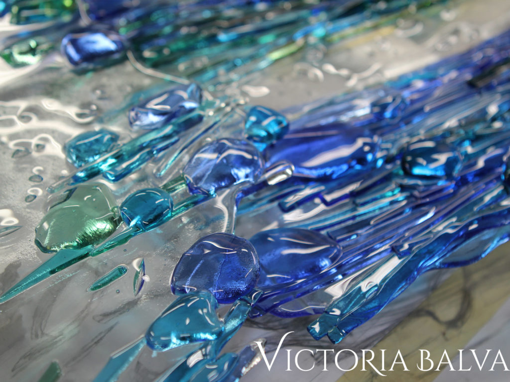 Fused textured blue glass on a clear cast base with curved glass edge