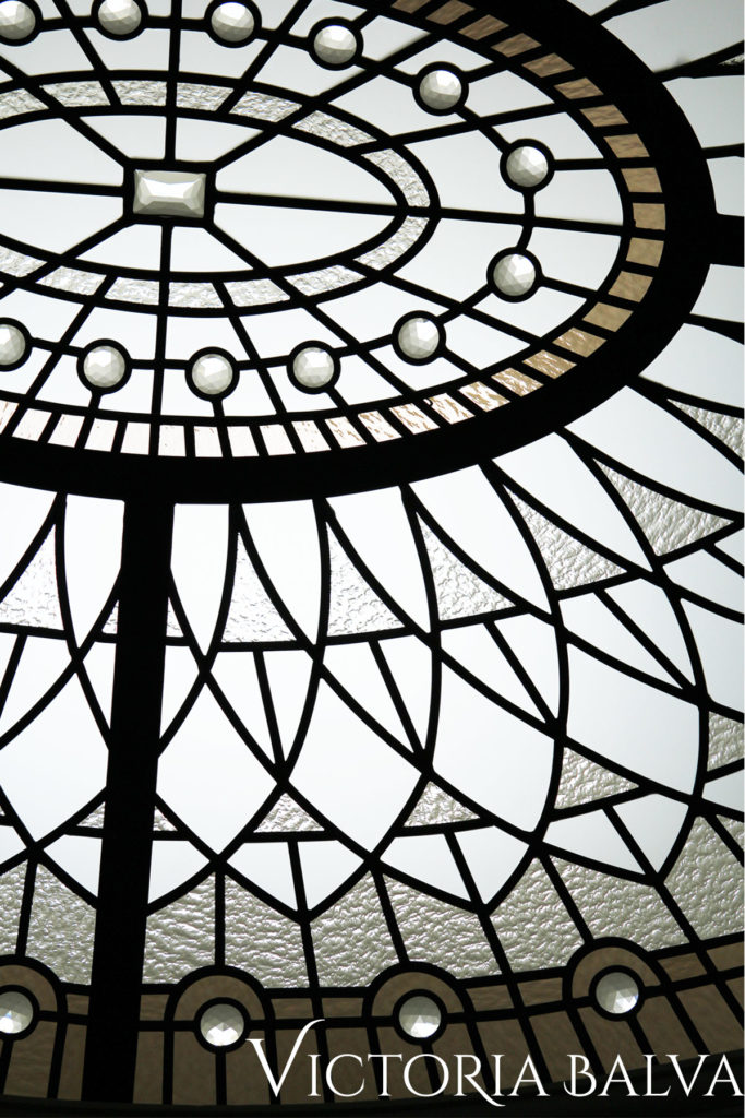 Rosette pattern ornament detail with acid etched glass and clear jewels on bronze border