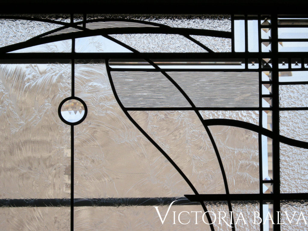 Modern stained glass window with artistic lines and clear bevelled glass