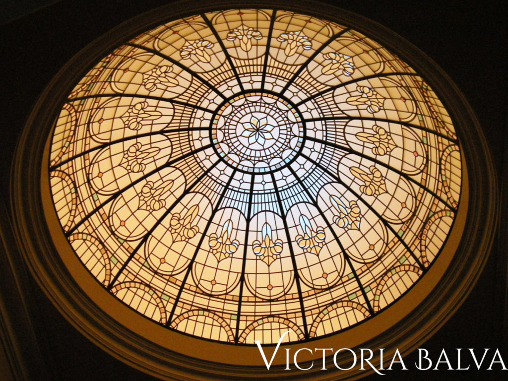 Stained and leaded glass dome in night time with additional light installed in the attic